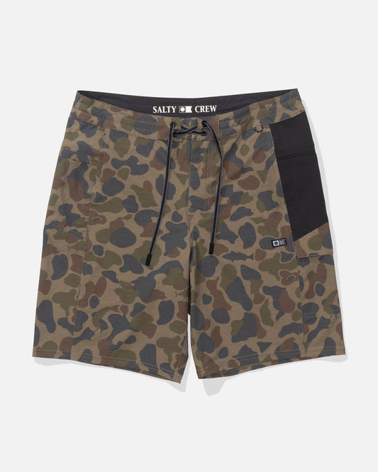 The Salty Crew Flagship 20" Boatshort in Sand Camo features green and brown camouflage, a black waistband and side pocket, drawstring closure, SALTY CREW branding, quick-dry ripstop fabric, and a durable front patch.