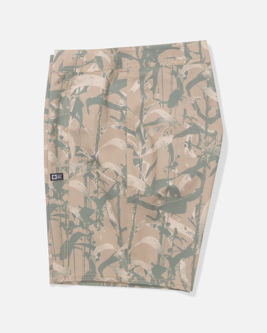 The Salty Crew Flagship 20" Boardshort in Kelp Camo features beige performance fabric with a green and white leafy pattern, a back pocket with a black logo tag on the left, and quick-dry tech. Displayed flat on a white background.