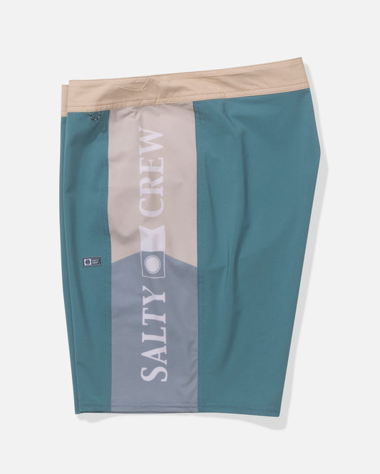 The Salty Crew Flagship 20" Boardshort - Oceanic features teal and beige colors, a beige waistband, beige side panel, SALTY CREW in large white letters, quick-dry performance fabric, and a zippered side pocket.