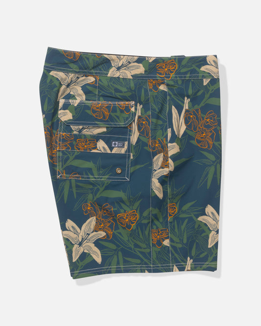 The Salty Crew Channel 18" Boardshort in Cast Blue features a tropical floral print with orange and white flowers, green leaves, a back pocket with button details, and quick-dry 4-way stretch fabric for comfort.