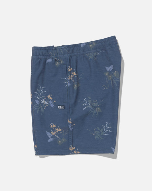 The Salty Crew Crew Volley 17″ shorts in Mid Blue feature a straight leg and an elastic waistband, adorned with a subtle floral and butterfly print in light yellow, green, and white tones. Made from recycled polyester with 4-way stretch for enhanced comfort and flexibility, these shorts are displayed flat against a plain white background.