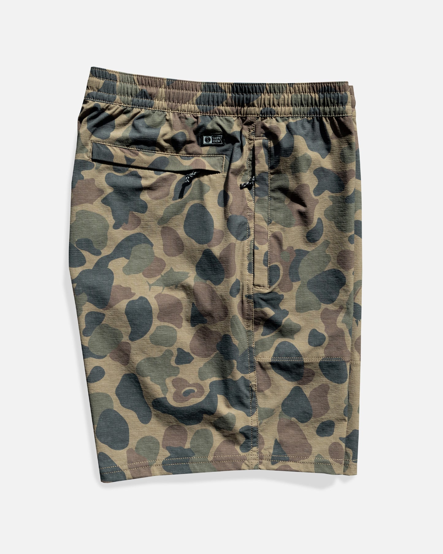 Salty Crew Crew 18" Boatshort Ewaist in Sand Camo features 4-way stretch ripstop fabric, elastic waistband with adjustable drawstring, side seam pockets, and a zippered back pocket, shown laid flat on a white background.