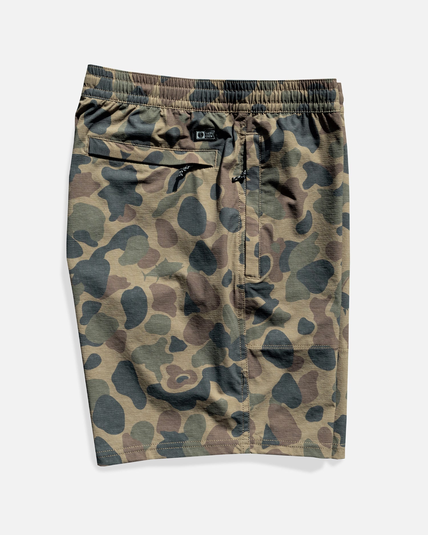 Salty Crew Crew 18" Boatshort Ewaist in Sand Camo features 4-way stretch ripstop fabric, elastic waistband with adjustable drawstring, side seam pockets, and a zippered back pocket, shown laid flat on a white background.