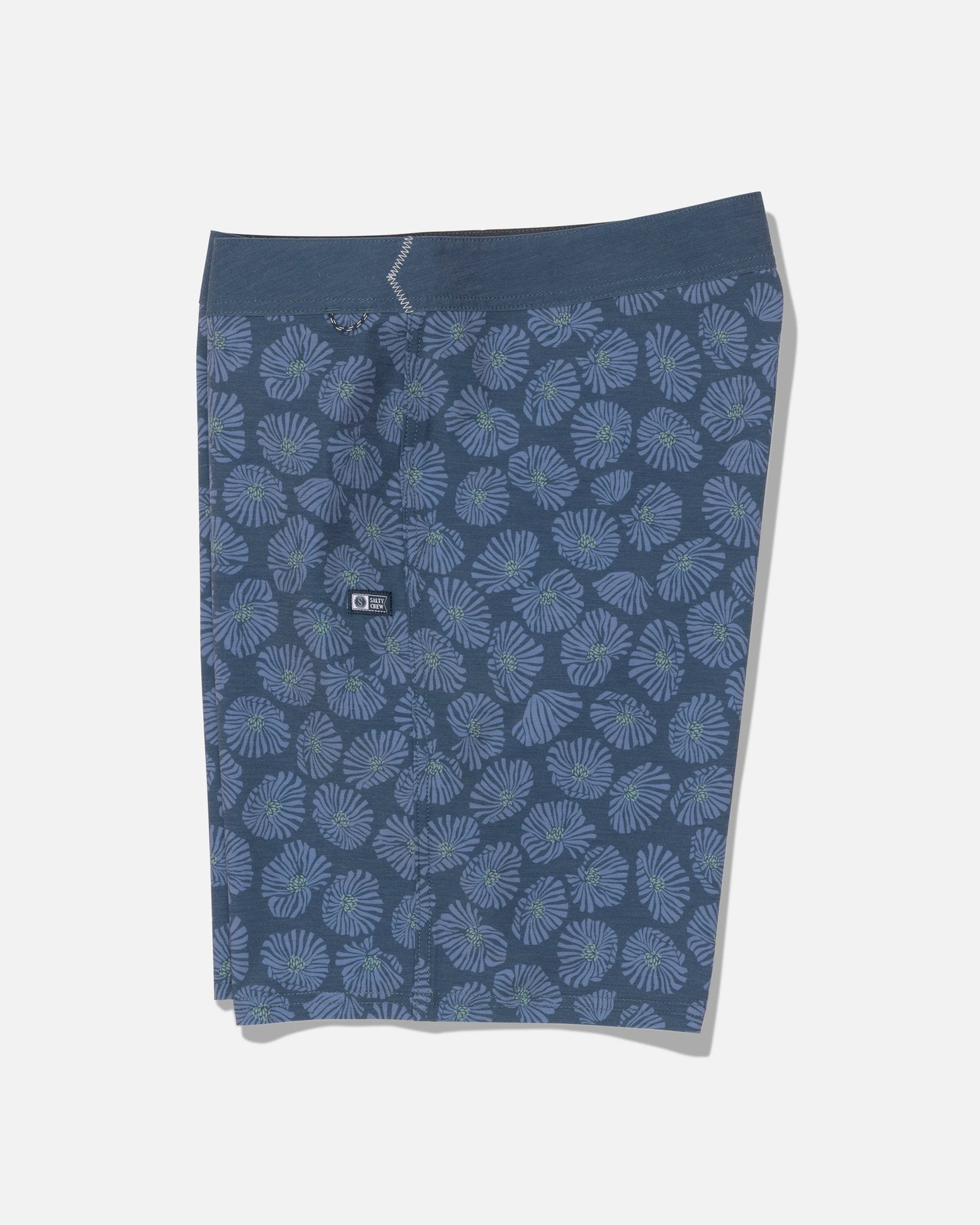 Crew 19″ Boardshort in Hitch Blue by Salty Crew, shown flat on a white background. These boardshorts feature a light blue and green floral pattern, crafted from recycled polyester with 4-way stretch for maximum comfort, and include a small black logo tag on the waistband.