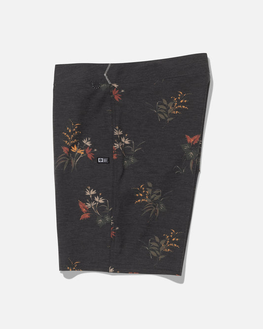 The Crew 19″ Boardshort - Off Black by Salty Crew is crafted from recycled polyester with 4-way stretch for optimal movement. These dark gray boardshorts feature a subtle floral pattern with red, orange, and yellow flowers, along with green leaves. Displayed flat against a white background, they include a small black logo patch on the left side.