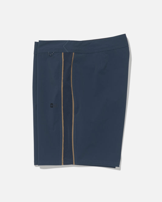 The Salty Crew Channel 18″ Apex Boardshort in navy features a straight-cut design with a vertical zipper and a contrasting tan stripe on one side, crafted from quick-dry fabric for added comfort and ease, displayed on a white background.