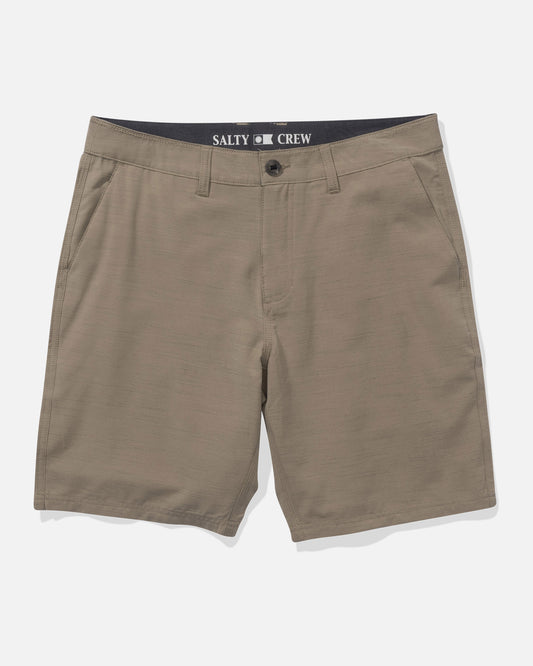 Salty Crew Drifter 19″ Slub Hybrid Shorts in khaki feature side pockets, a button and zip closure, and Salty Crew branding on the inner waistband. Made from recycled performance fibers with quick dry technology, these men’s shorts offer comfort and versatility. Shown laid flat on a white background.