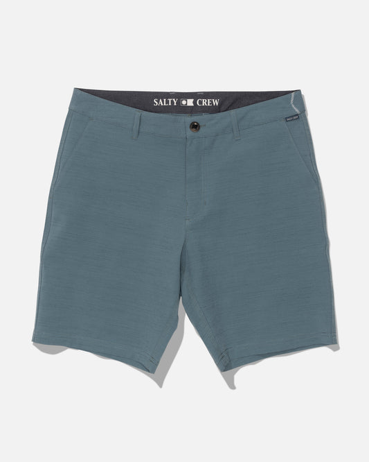 Salty Crew Drifter 19″ Slub Hybrid shorts in Mid Ocean are men’s blue shorts featuring belt loops, front pockets, and a button closure. Made from recycled performance fabric with 4-way stretch for optimal comfort and freedom of movement, these shorts are built for your active lifestyle. Quick-dry technology helps you stay cool and comfortable throughout the day. “Salty Crew” is printed inside the waistband, and the shorts are displayed laid flat on a white background.