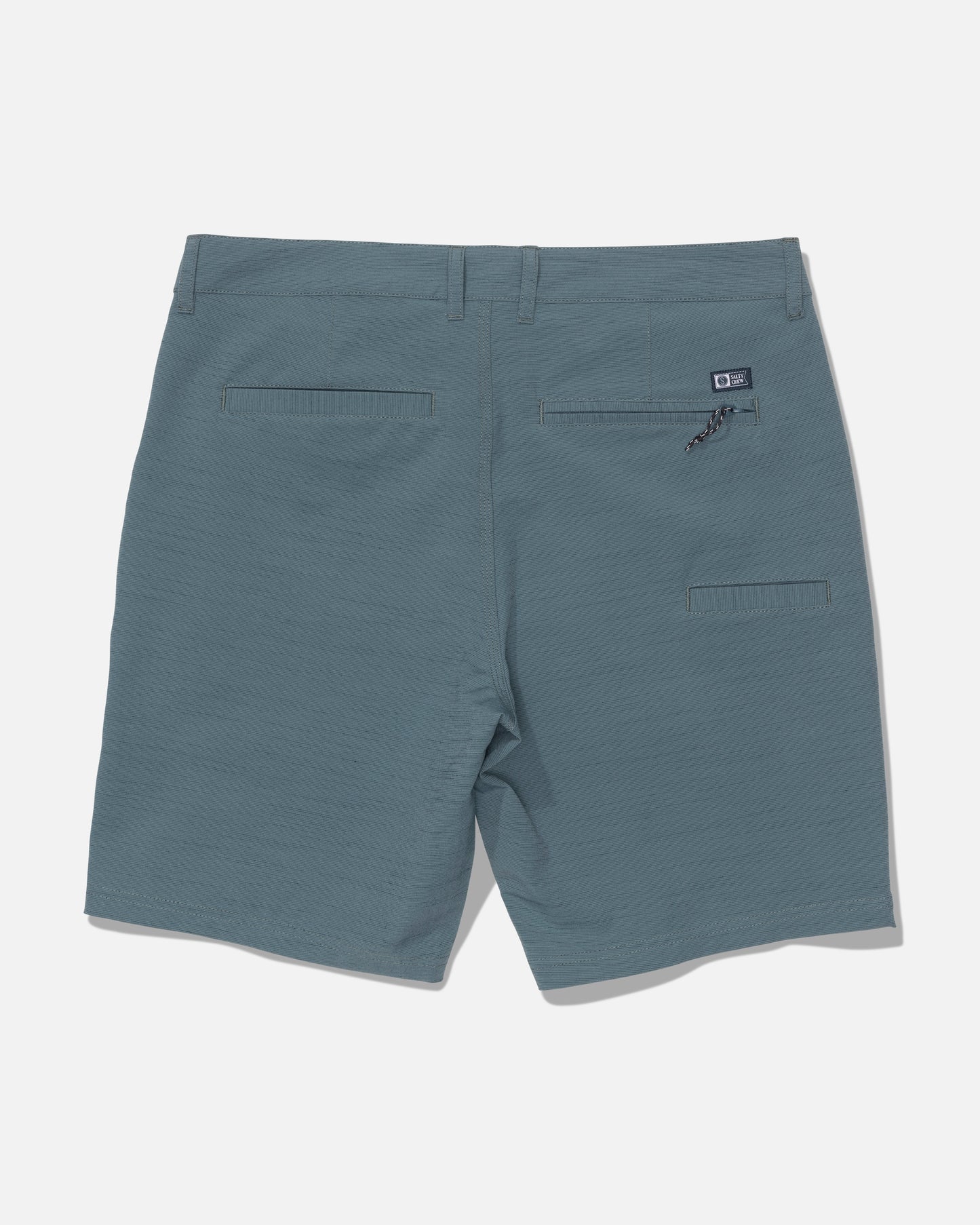 Back view of the Salty Crew Drifter 19″ Slub Hybrid shorts in Mid Ocean blue, showcasing belt loops, two back pockets—including one with a zipper—and a small black Salty Crew logo patch above the right pocket, crafted from recycled performance fabric with 4-way stretch for superior comfort and mobility, set against a white background.