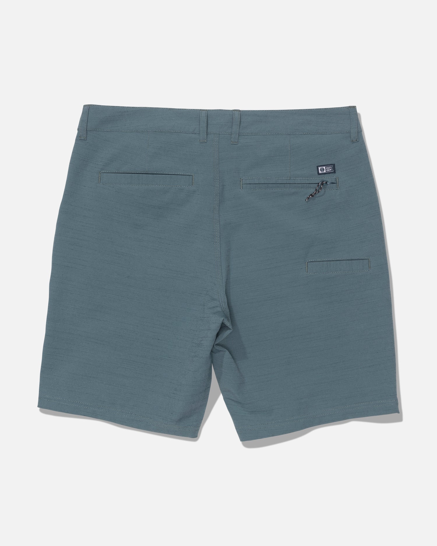 Back view of the Salty Crew Drifter 19″ Slub Hybrid shorts in Mid Ocean blue, showcasing belt loops, two back pockets—including one with a zipper—and a small black Salty Crew logo patch above the right pocket, crafted from recycled performance fabric with 4-way stretch for superior comfort and mobility, set against a white background.