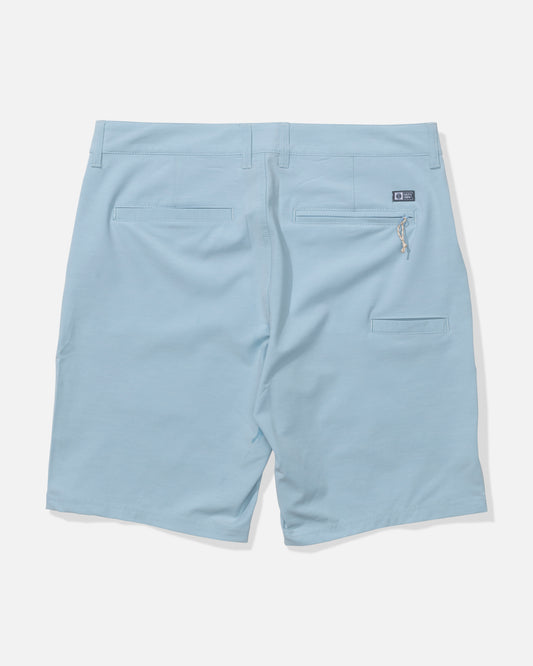 The Salty Crew Drifter 19" Hybrid Short in Mineral Blue features recycled 4-way stretch fabric, belt loops, two back pockets (one zippered), and a small rectangular logo patch above the right pocket. Shown from the back.