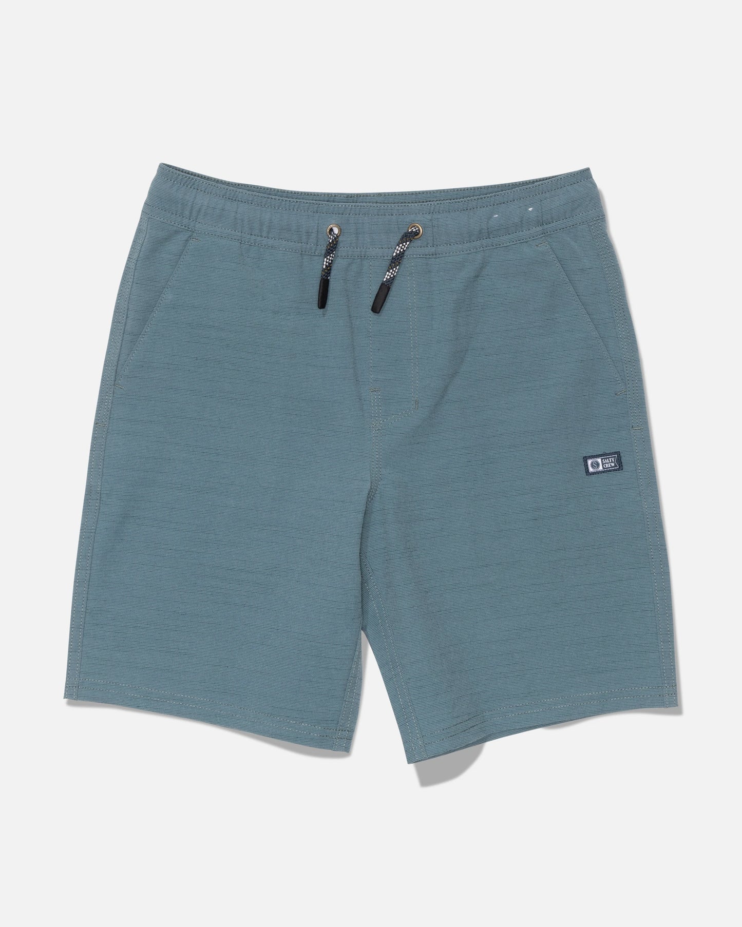 Salty Crew Drifter 16″ Boys Elastic Hybrid shorts in Mid Ocean feature a blue-green hue, straight leg cut, elastic waistband with black drawstrings, and convenient side pockets. Made from a comfortable and durable polyester cotton blend, these shorts display a small rectangular logo patch on the left leg and are shown laid flat on a white background.