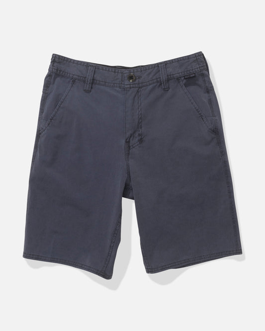 The Salty Crew Transom 17" Boys Overdye Short in Magnet is a pair of dark blue, straight-leg shorts with 4-way stretch, front pockets, belt loops, and a button closure, shown flat on a white background.