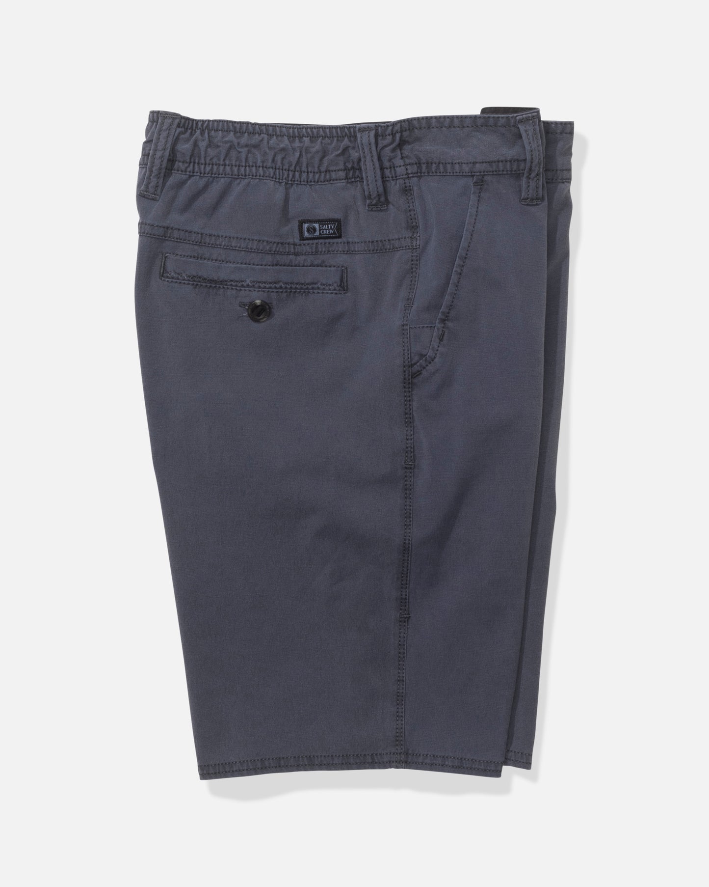 The Salty Crew Transom 17" Boys Overdye Short in Magnet features a dark gray straight leg design with an elastic waistband, belt loops, a buttoned back pocket, and visible stitching, shown on a plain white background.