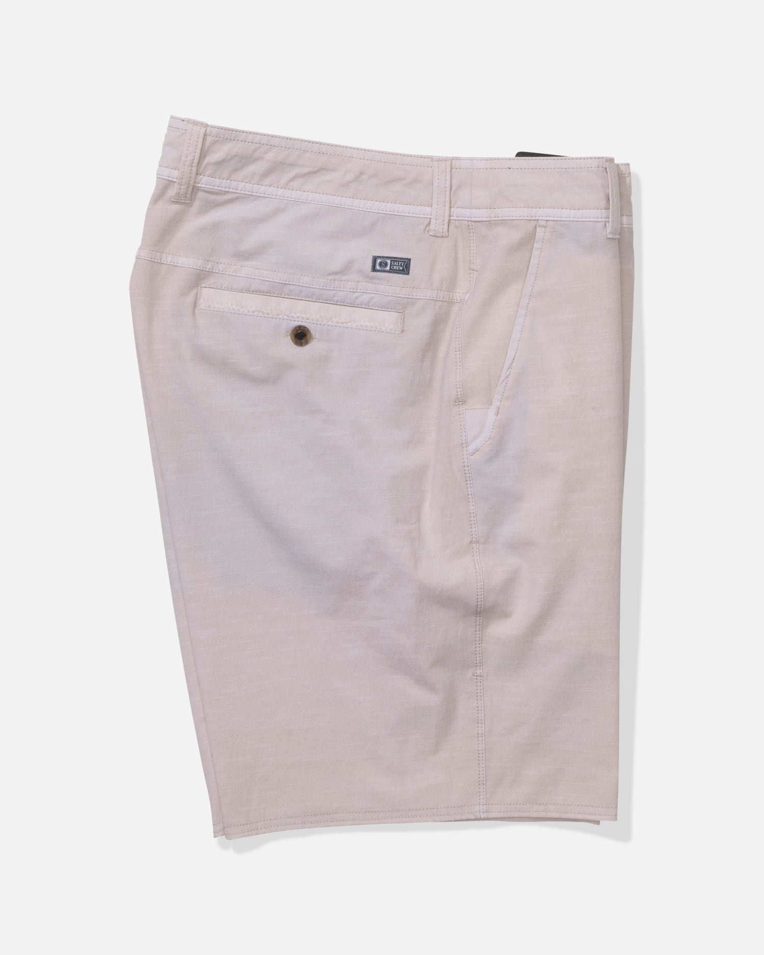 The Salty Crew Transom 19" Overdye Short in Natural features belt loops, a buttoned back pocket with a rectangular logo tag, and quick-dry fabric. These straight-leg shorts are shown against a plain white background.