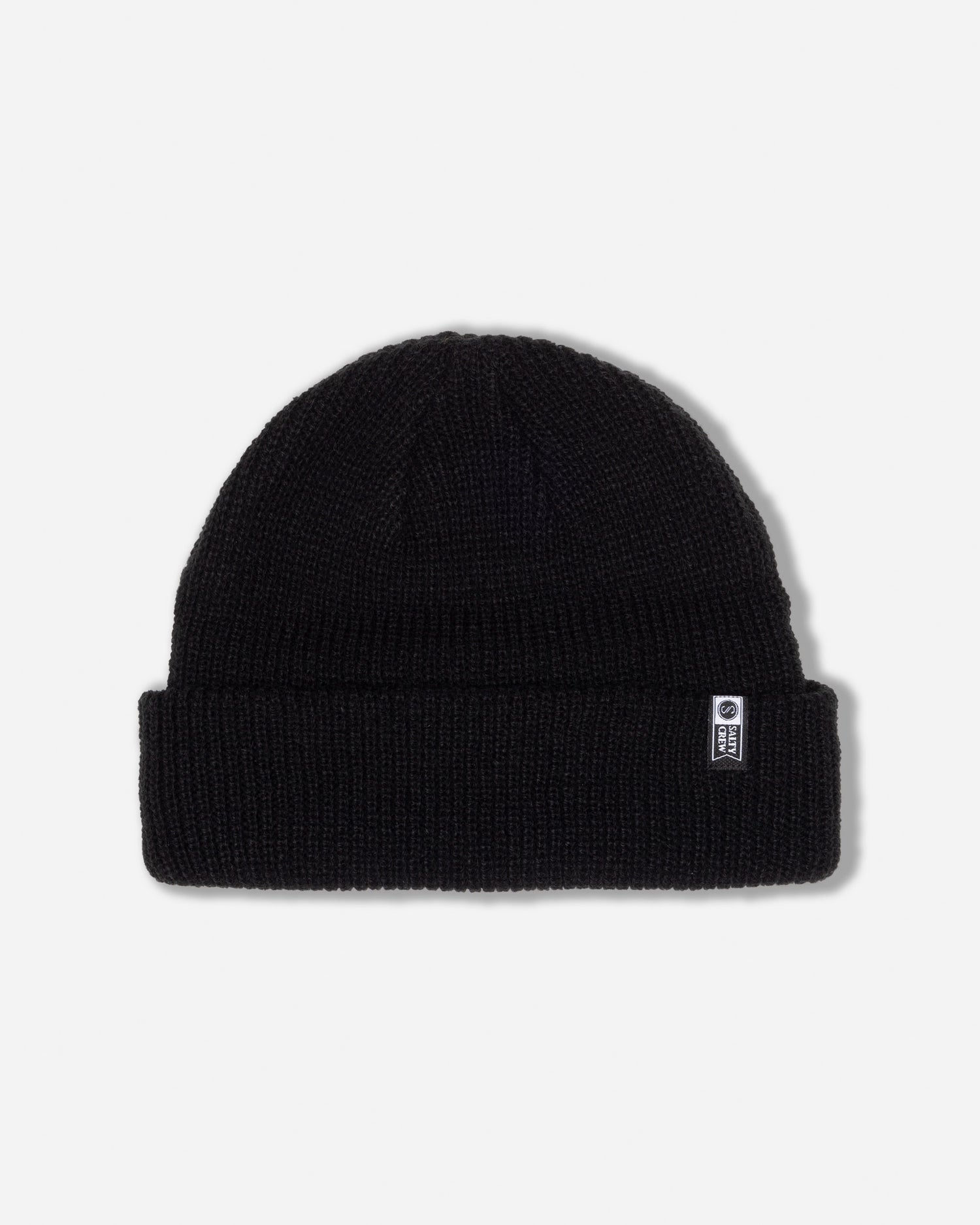The Salty Crew Alpha Beanie in Off Black features a folded brim and a small rectangular woven label on the front right side, and is shown against a plain white background.