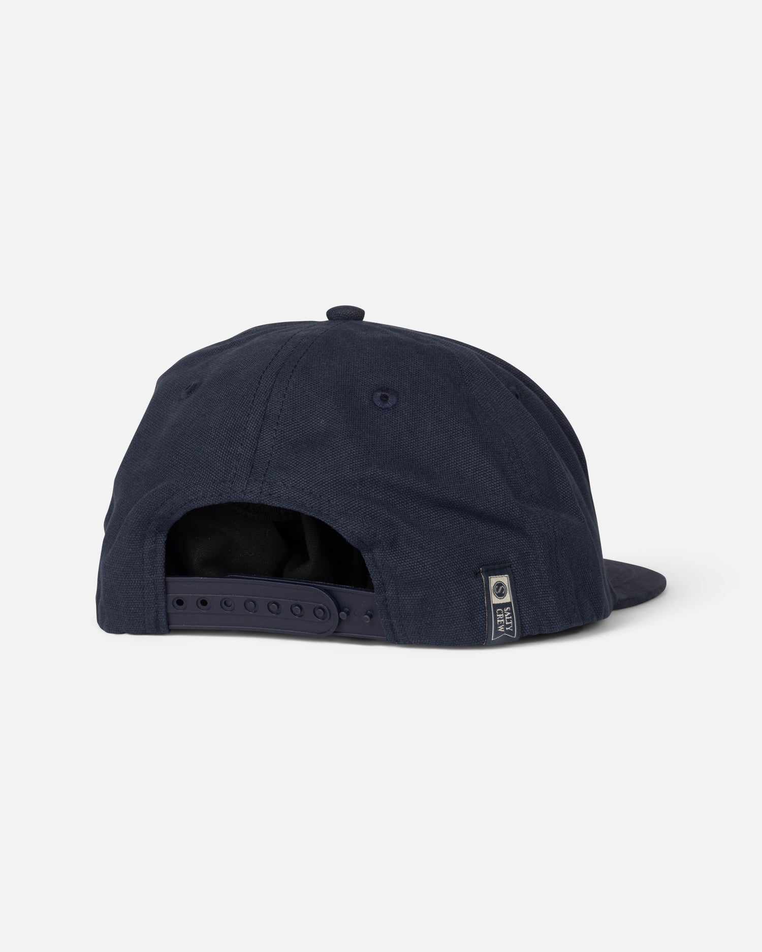 The Salty Crew Coastal Boys Snapback in Midnight Navy is shown from the back, displaying its adjustable snapback closure and a small logo tag on the lower right. The background is plain light gray.