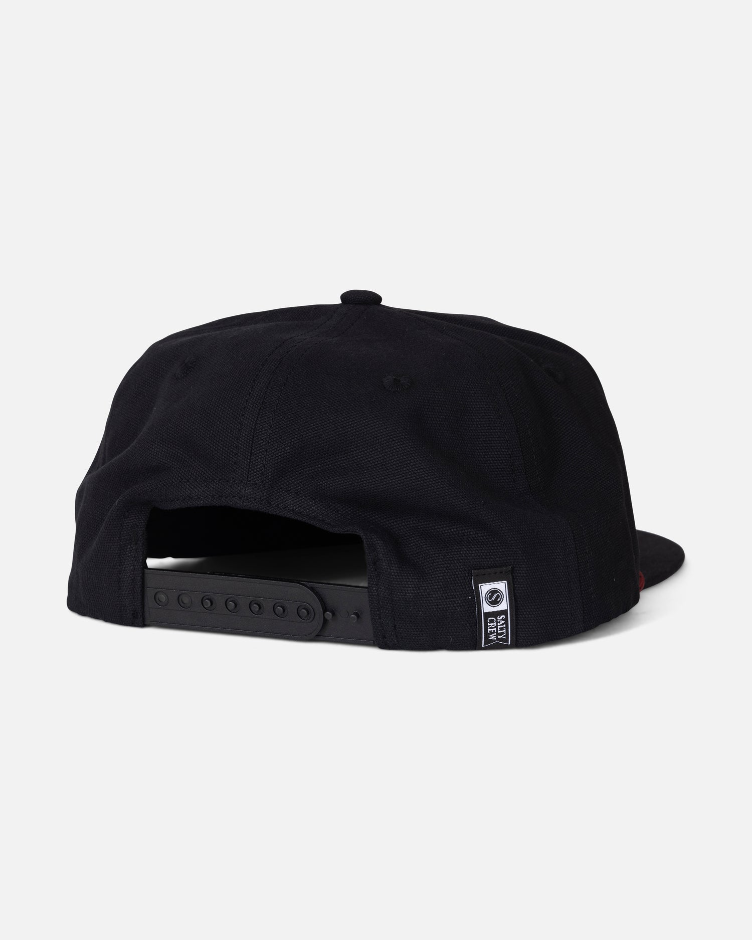 The Salty Crew Coastal Snapback - Black is displayed from the back against a plain white background. Made from durable cotton canvas, it features a five-panel design, an adjustable snapback strap, and a small black-and-white Salty Crew tag near the opening.