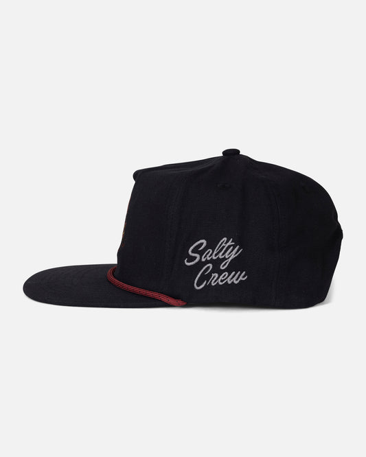 The Coastal Snapback - Black by Salty Crew is a black 5-panel flat-brim snapback hat, featuring the Salty Crew logo embroidered in white script on the side. Crafted from durable cotton canvas, it includes a red accent above the brim and is showcased against a plain light background.