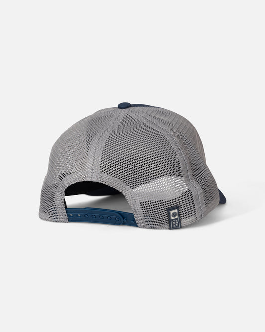 Here is your rewritten sentence using the provided product data: The Salty Crew Fishing Club Trucker - Navy/Grey is shown from the back, displaying its low crown trucker-style baseball design with a mesh back, navy plastic snapback closure, and a Salty Crew brand tag at the bottom right. This cotton snapback hat is photographed against a plain light grey background.