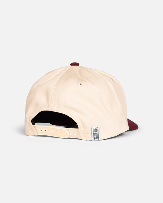 The Salty Crew Coordinates Snapback Hat in Off White/Red features an adjustable strap and maroon brim, shown from the back with a rectangular tag by the strap, displayed against a plain white background.