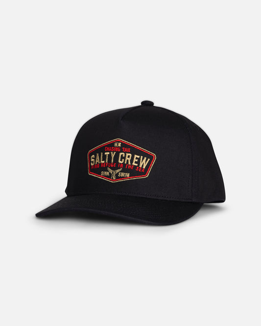 The Tailfin Boys Snapback - Black by Salty Crew is a black cotton 5-panel hat featuring a red and yellow embroidered patch on the front that reads “Salty Crew” and “Chasing Tail.” The snapback cap is photographed against a plain white background.