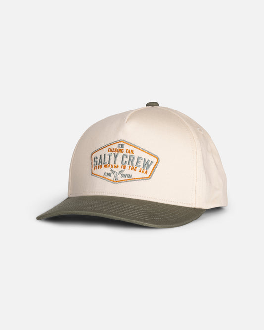 The Tailfin Boys Snapback by Salty Crew features an off white crown with a green brim, adorned with a diamond-shaped Salty Crew patch on the front and other subtle text details. Crafted from cotton in a high crown snapback style, this cap stands out against a plain white background.