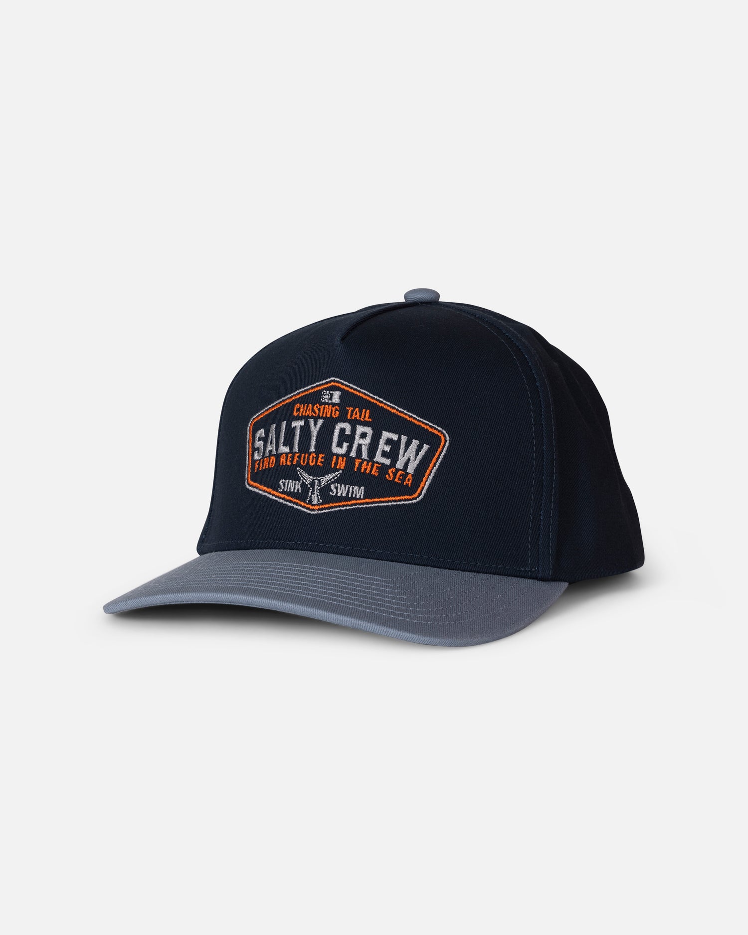 A mid blue and gray cotton snapback baseball cap with a curved brim. The front features an embroidered patch with “Salty Crew” in orange and white text, along with additional smaller text. This is the Tailfin Snapback by Salty Crew.