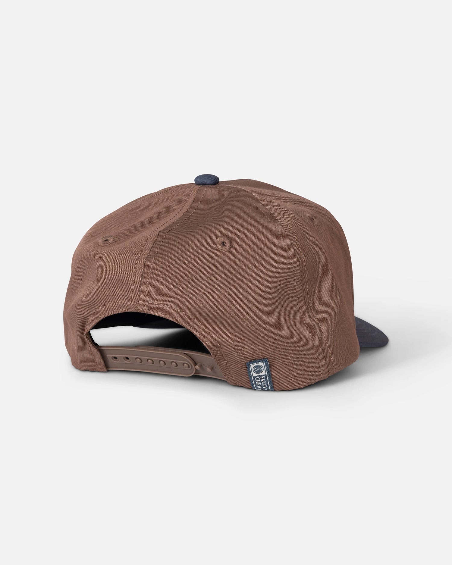 The Salty Crew Reel Repair Snapback in Brown/Navy is a structured 5-panel baseball cap crafted from durable cotton canvas, featuring an adjustable snapback closure and a small fabric tag near the opening. Its classic silhouette is complemented by a dark navy brim and a button on top.