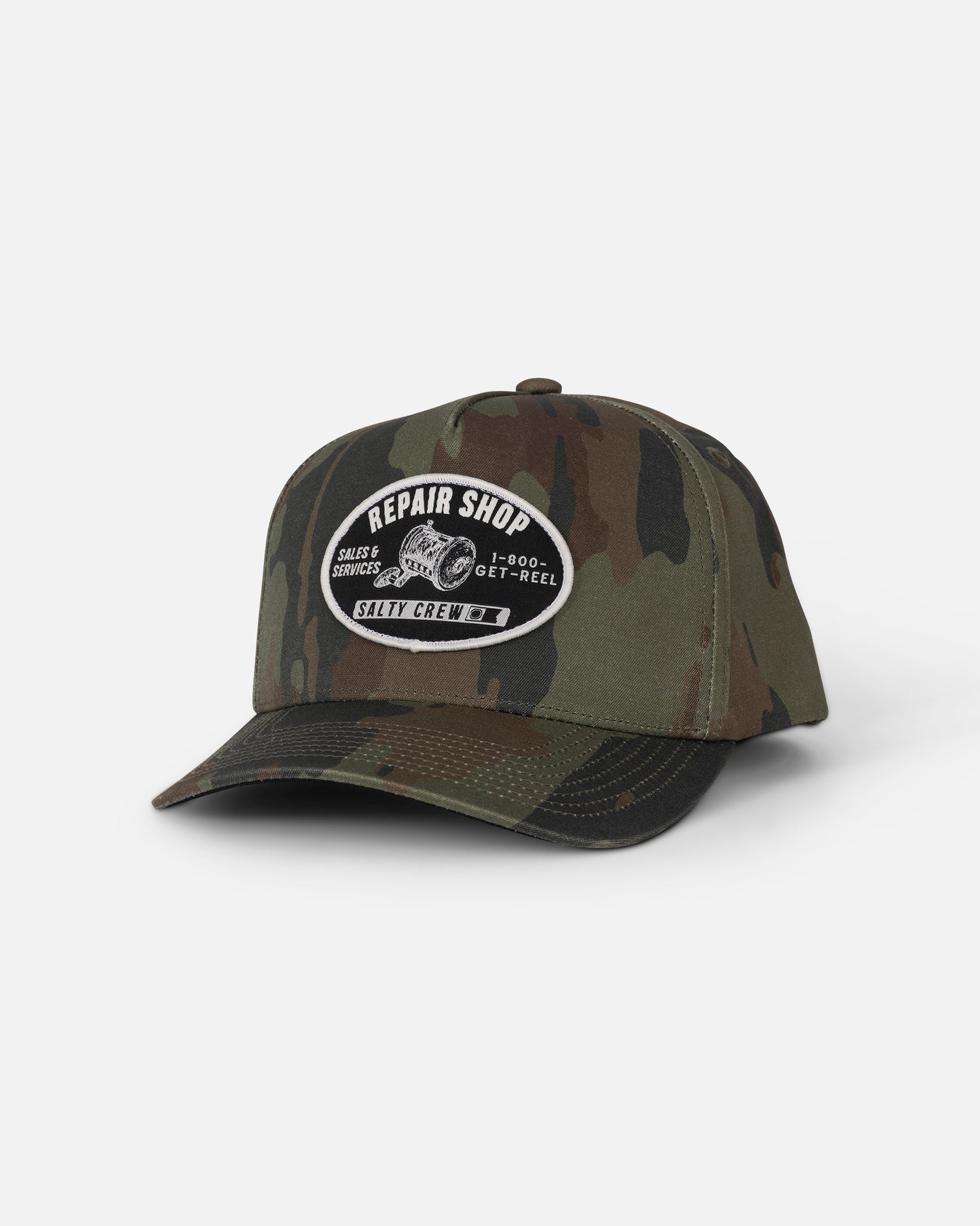 Reel Repair Snapback - Ranger by Salty Crew: a green camouflage cotton canvas snapback baseball cap featuring a black-and-white woven patch with “Repair Shop” and “Salty Crew” text plus a fishing reel graphic, shown on a plain white background.