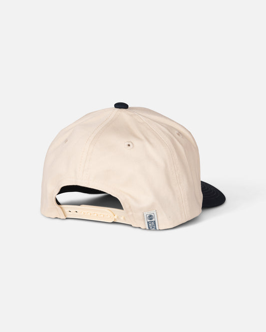 The Salty Crew Coordinates Snapback in Off White/Navy is displayed from the back, highlighting its adjustable strap and a small rectangular label near the closure, set against a plain white background.