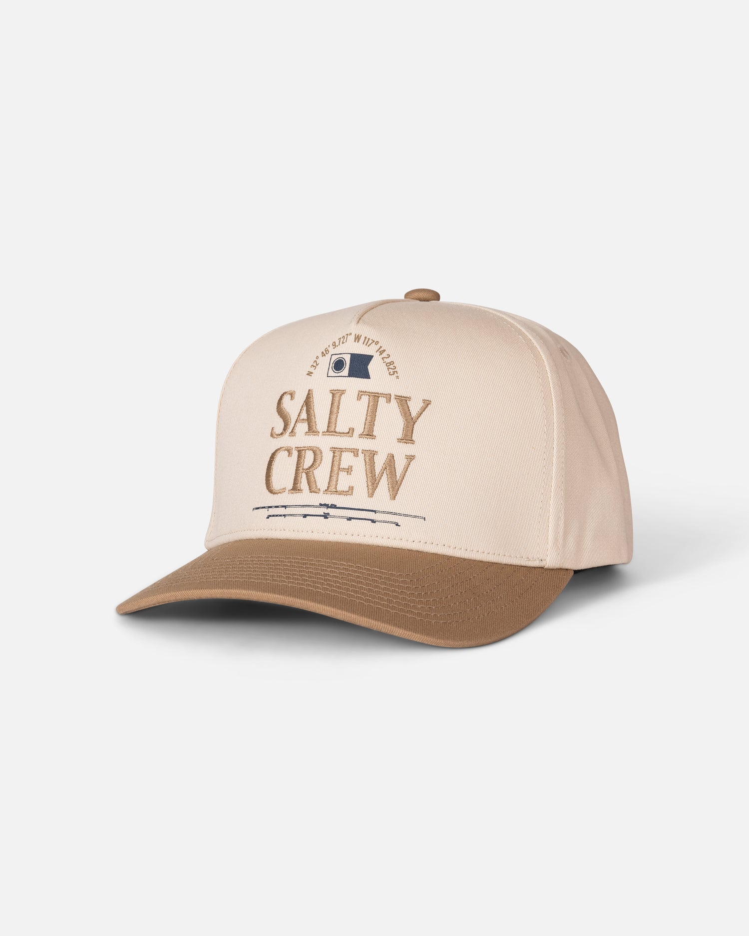 The Salty Crew Coordinates Snapback in Off White/Tan is a cotton high-crown snapback cap featuring beige and brown embroidery, “Salty Crew” stitched on the front, a small patch above the text, and a curved brim. The cap is displayed on a white background.
