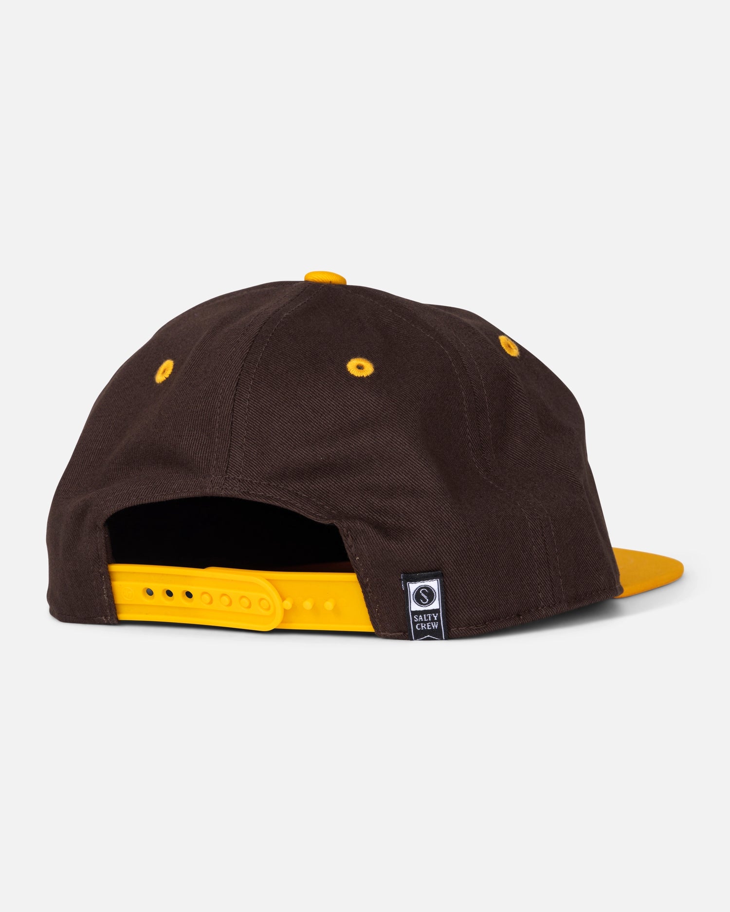 A brown and gold Padres Tippet Hat by Salty Crew is shown from the back, featuring a yellow adjustable strap, gold eyelets, and a small black rectangular tag near the opening. This limited edition snapback cap takes inspiration from the classic San Diego Padres hat for a unique, standout look.