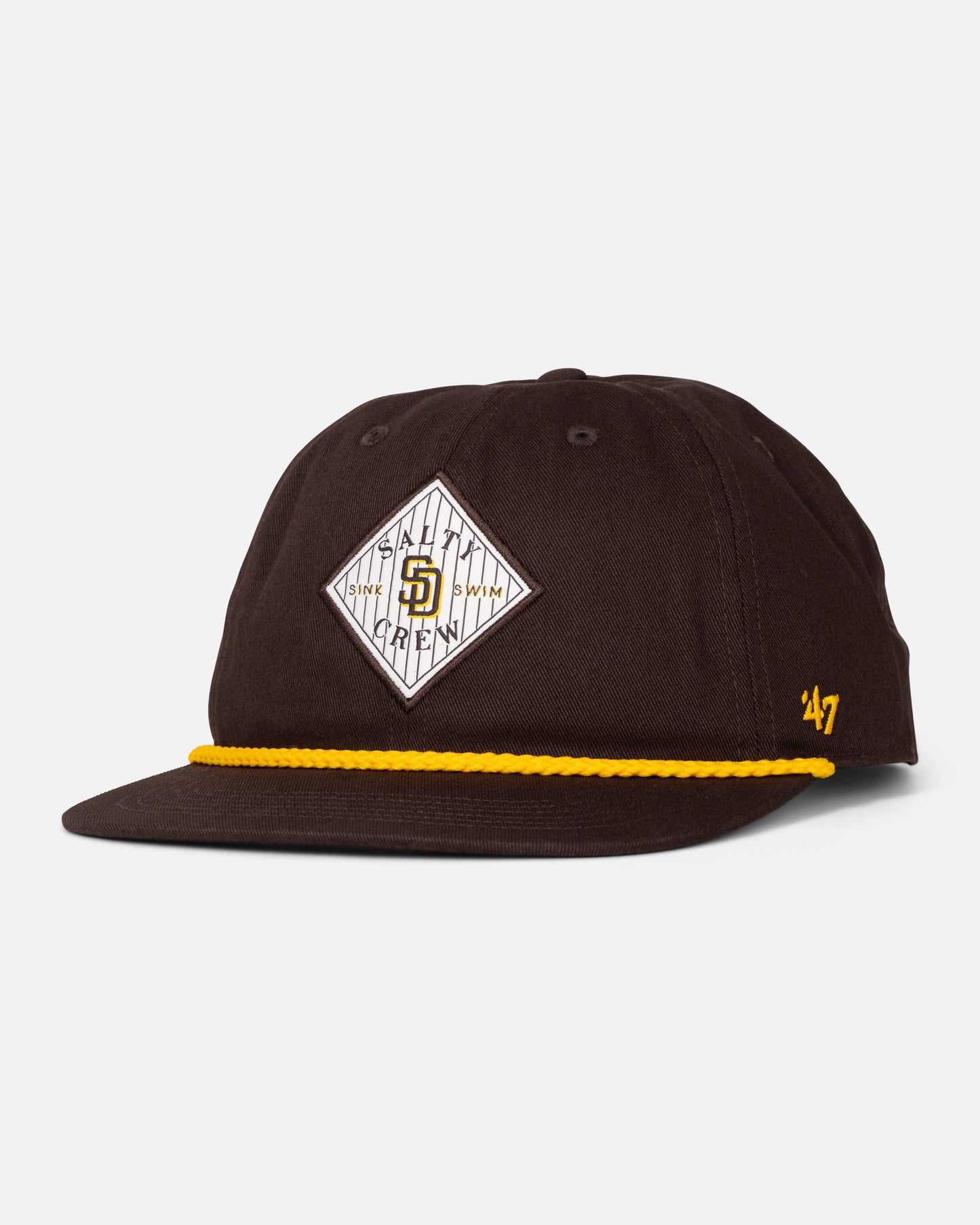A limited edition Padres Tippet Hat by Salty Crew, in brown, featuring a yellow cord above the brim, a diamond-shaped Padres patch on the front, and a gold Salty Crew logo on the left side.