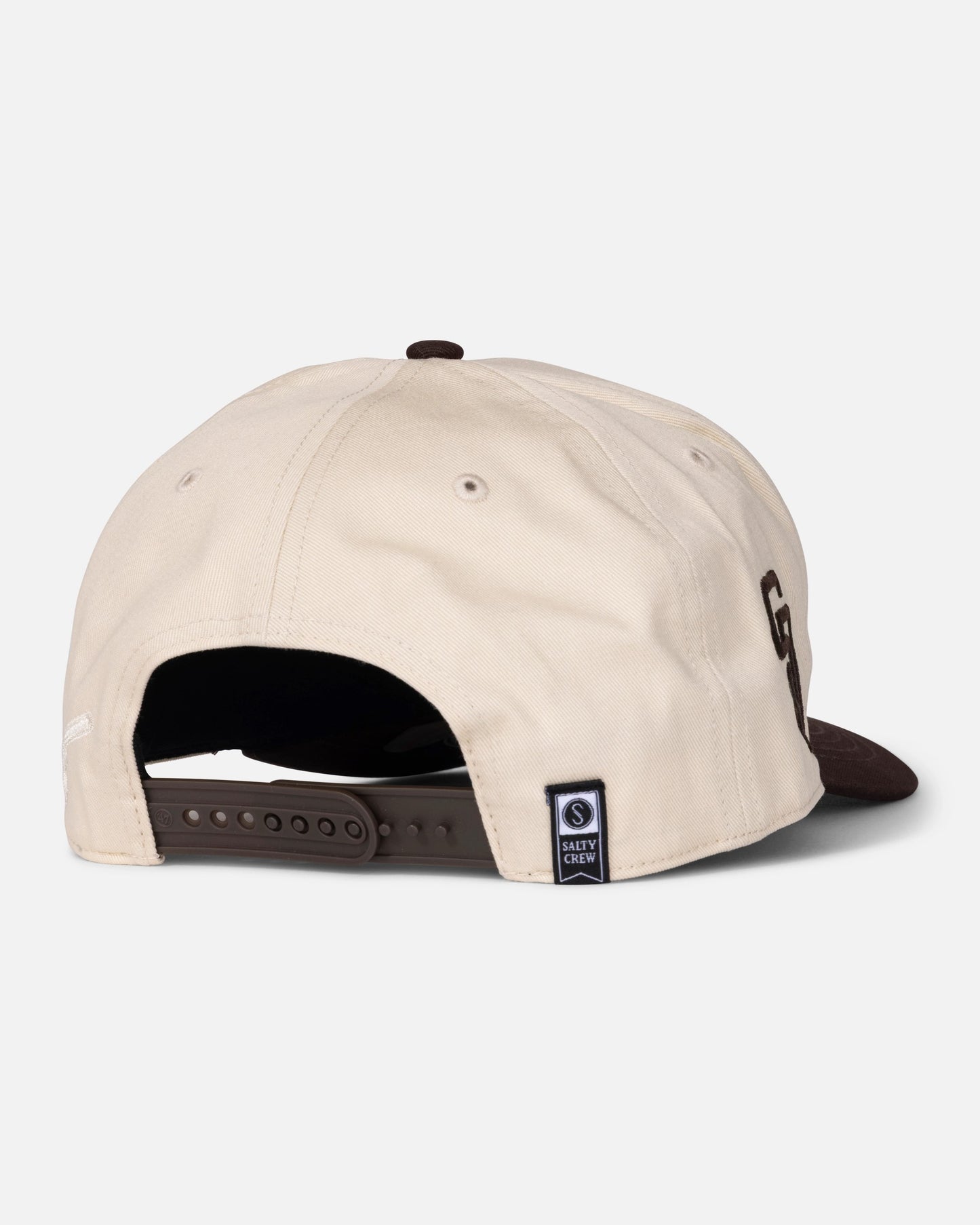 A beige and brown Padres Swingin Friar Hat - Bone, viewed from the back, features an adjustable snapback closure and a small navy label with text and a logo near the opening. This limited edition hat by Salty Crew combines comfort with exclusive style.