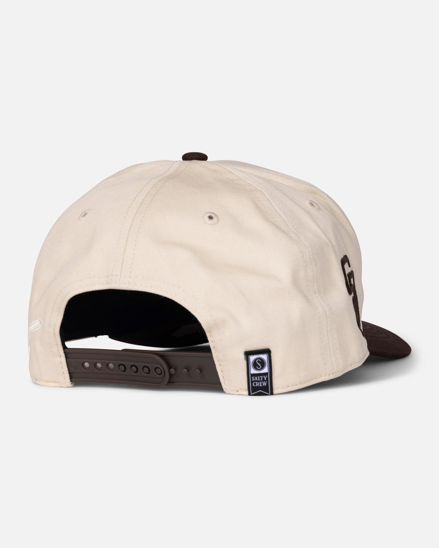 A beige and brown Padres Swingin Friar Hat - Bone, viewed from the back, features an adjustable snapback closure and a small navy label with text and a logo near the opening. This limited edition hat by Salty Crew combines comfort with exclusive style.