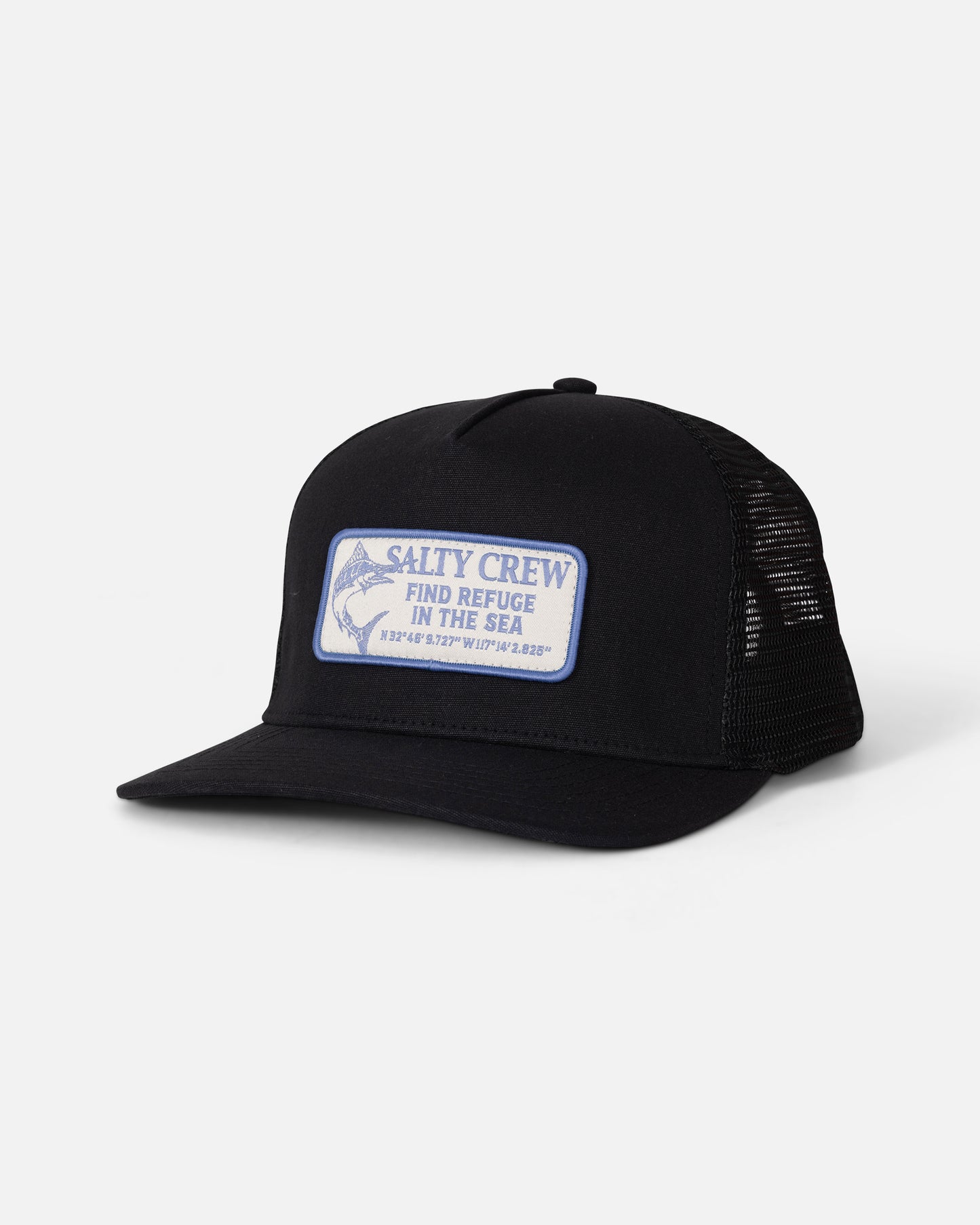 The Salty Crew Coordinates Trucker - Black is a high crown snapback profile trucker hat, crafted with black mesh panels and a cotton snapback closure. It features a white and blue patch with the words “Salty Crew Find Refuge in the Sea” and coordinates on the front, displayed against a plain white background.
