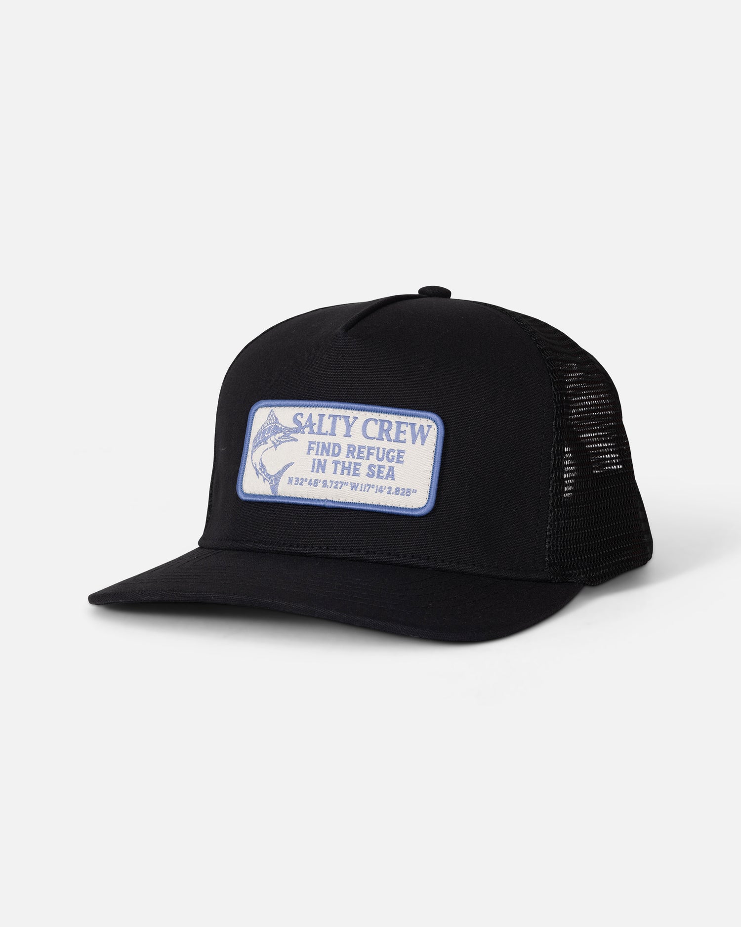 The Salty Crew Coordinates Trucker - Black is a high crown snapback profile trucker hat, crafted with black mesh panels and a cotton snapback closure. It features a white and blue patch with the words “Salty Crew Find Refuge in the Sea” and coordinates on the front, displayed against a plain white background.