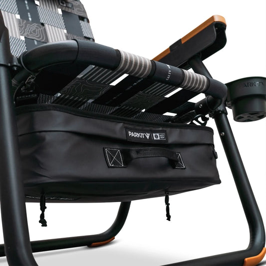 A Parkit x Salty Crew Eclipse Recliner chair featuring a black storage cooler attached beneath the seat and a built-in cup holder on the armrest.