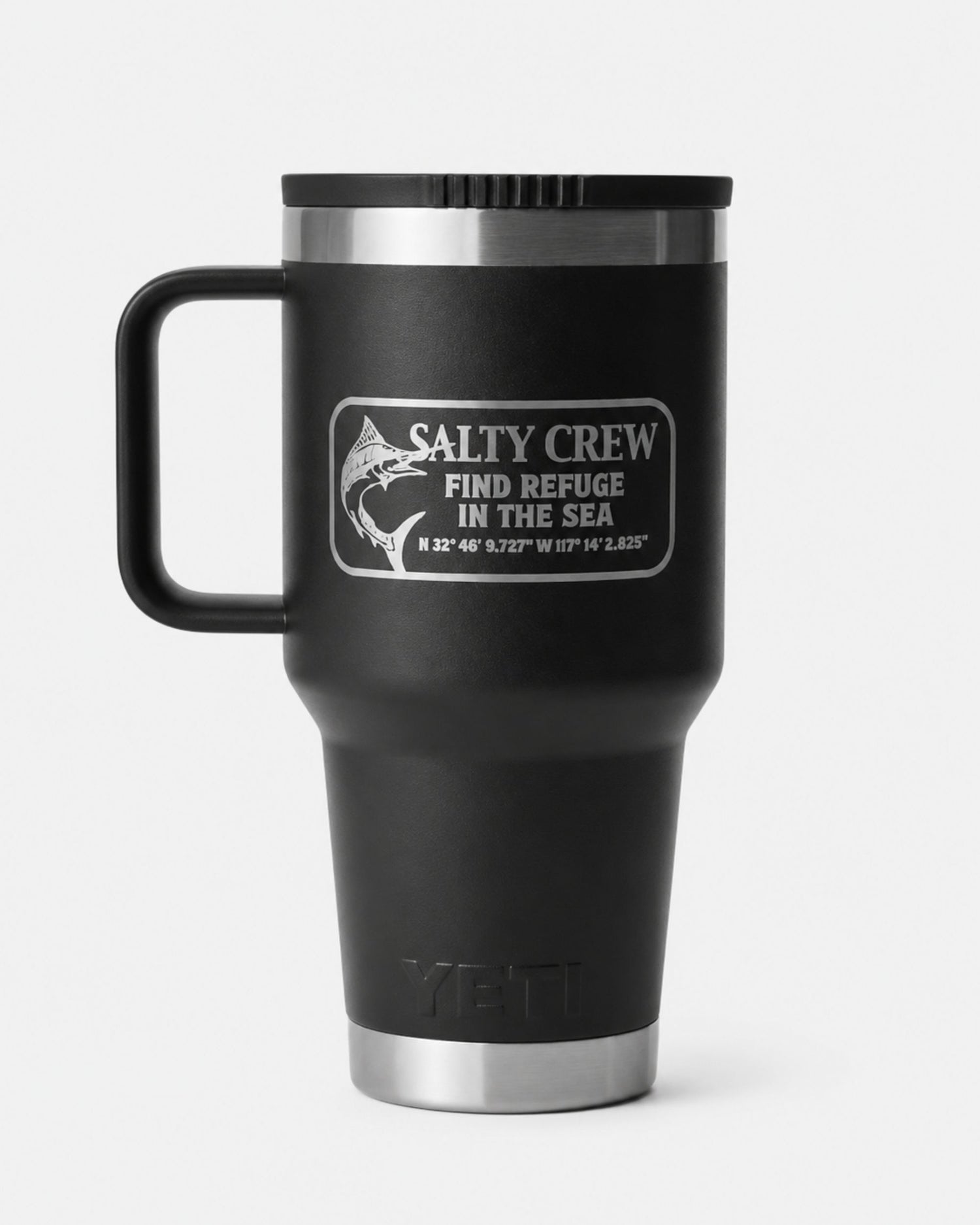 The Salty Crew Yeti x Salty Crew Travel Straw Mug 30 Oz in black is a vacuum-insulated stainless steel mug with handle, featuring a fish graphic, coordinates, and "Find Refuge in the Sea" on a crisp white background.