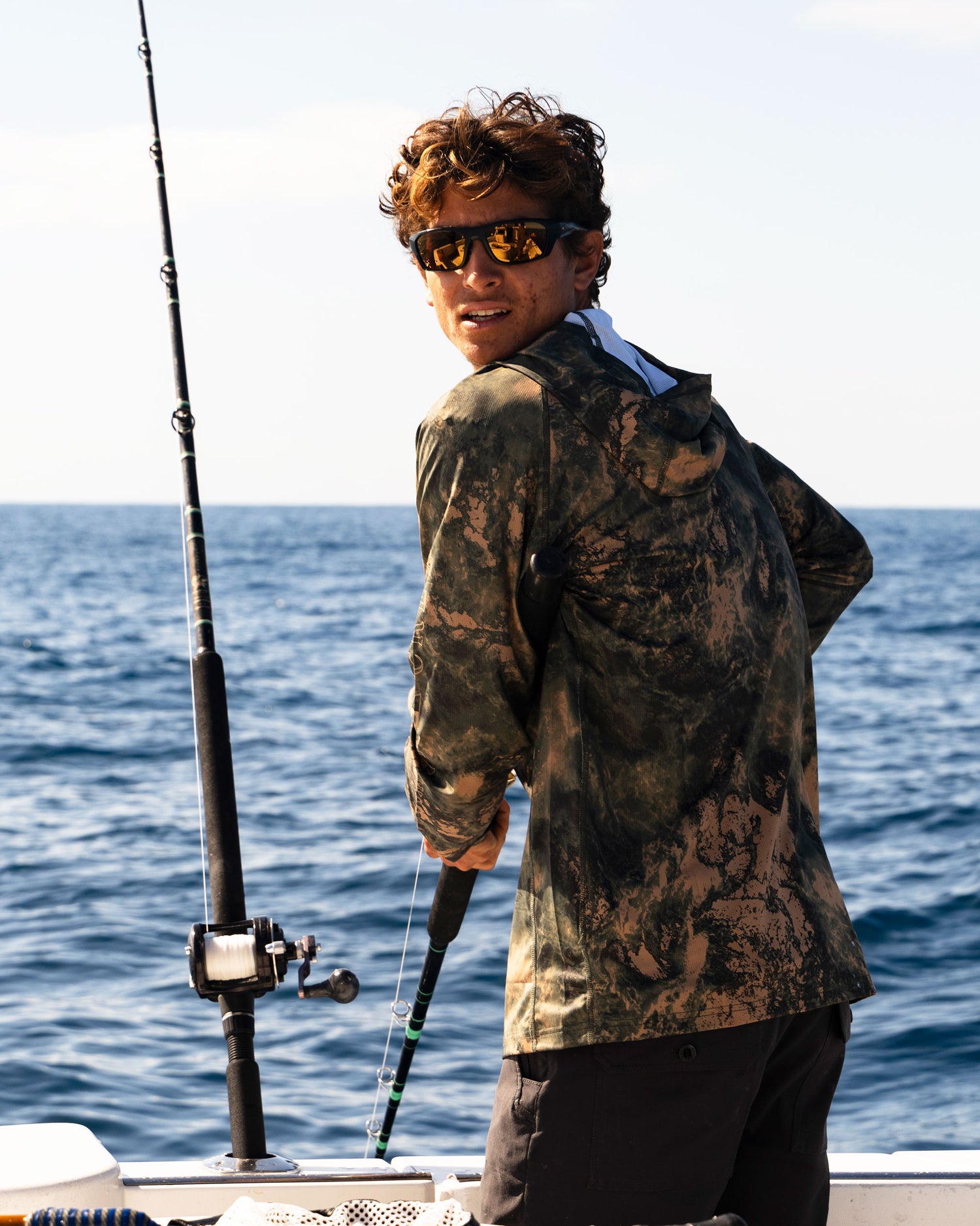 Lifestyle shot of the Apex Perforated Sunshirt Hoodie - Deep Forest. 