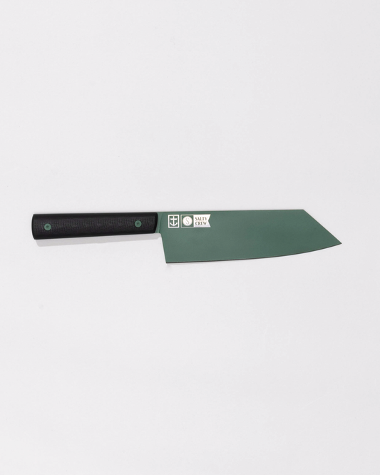 The Leucadia x Salty Crew 7” Bunka Knife by Salty Crew features a green AEB-L Swedish stainless steel blade with two small logos and “Navy 2014,” plus a black handle—all shown on a white background. Limited edition.