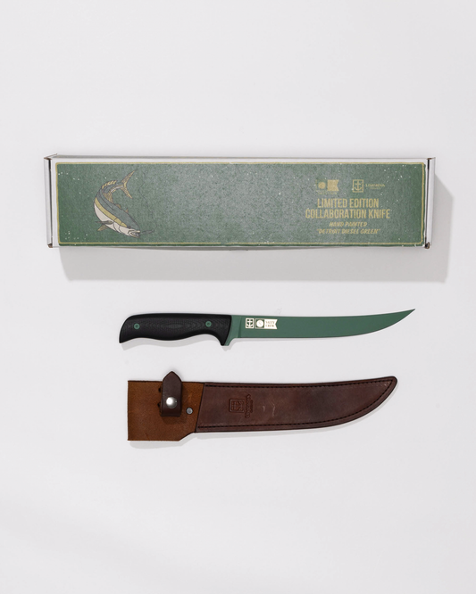 The Salty Crew Leucadia x Salty Crew 8” Hamachi Fillet Knife features a Detroit Diesel Green cerakote handle, curved blade, brown leather sheath, and comes in a green box with fish art—all displayed on a white background.