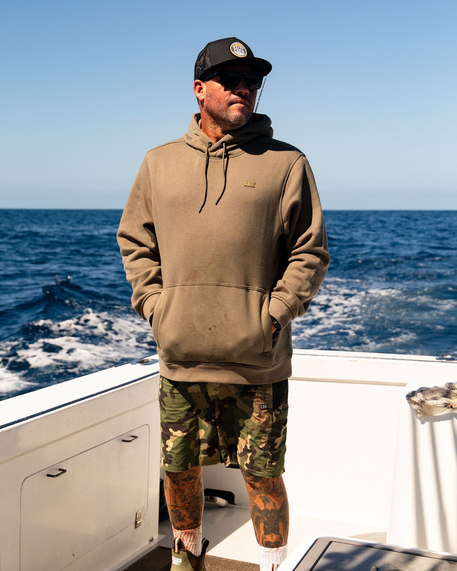 Lifestyle shot of the Long Range Tech Fleece Hoodie - Olive. 
