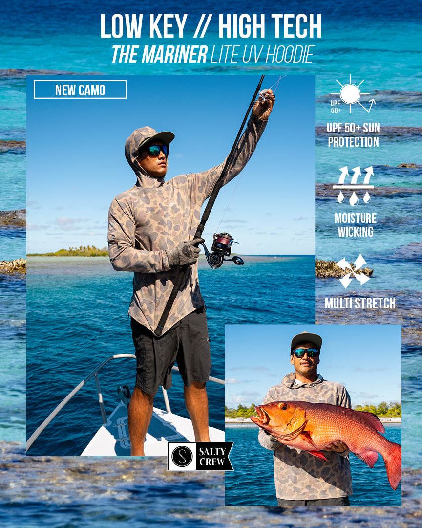 A man sporting the Salty Crew Mariner Lite UV Hood in Tan Camo, paired with sunglasses and a cap, fishes from a boat on clear blue water. Inset: he proudly displays a large fish. Text highlights include UPF 50+ sun protection, moisture-wicking performance, and lightweight stretch fabric for all-day comfort.