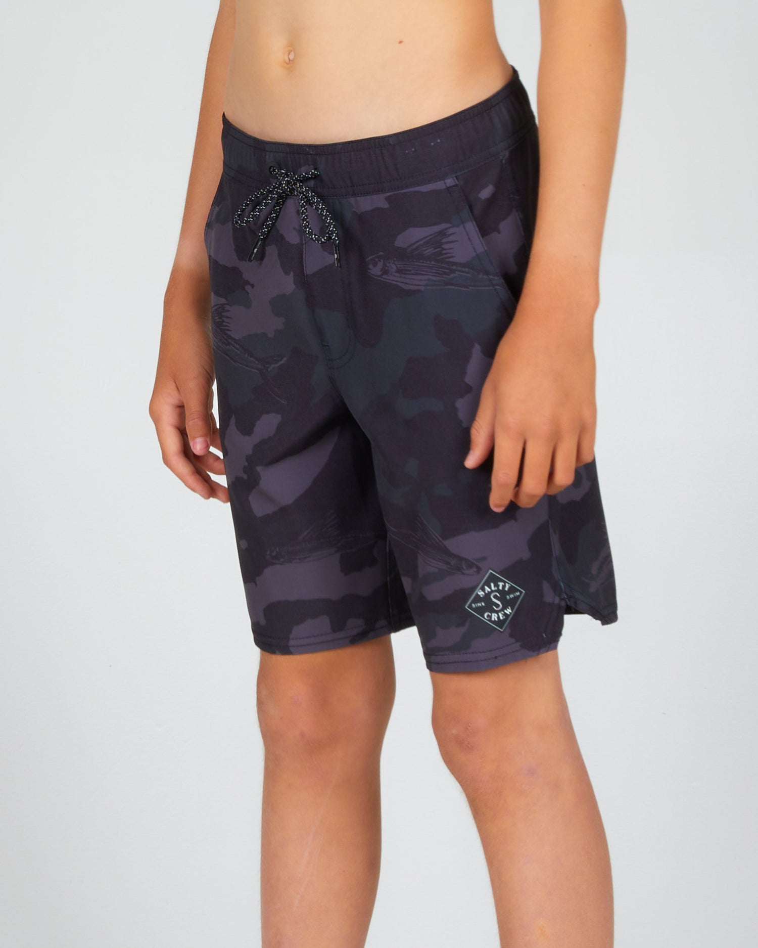 On body front angled view of the Lowtide Boys Black Camo Elastic Boardshort